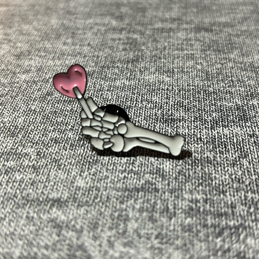Skeleton Hand Holding Pink Heart Shaped Lollipop Enamel and Metal Pin
